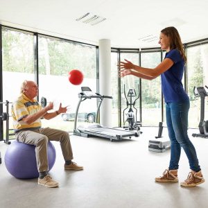 Oudere man op oefenbal tijdens fysiotherapie | Fysio Stenia Zeist